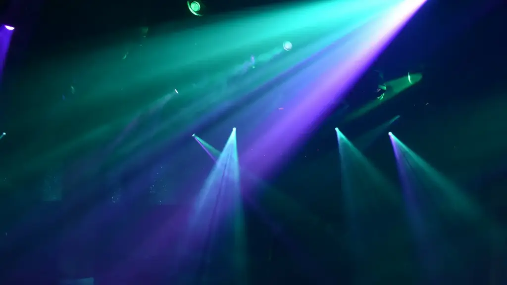 Haces de luz azules y verdes sobre la pista de baile en una fiesta