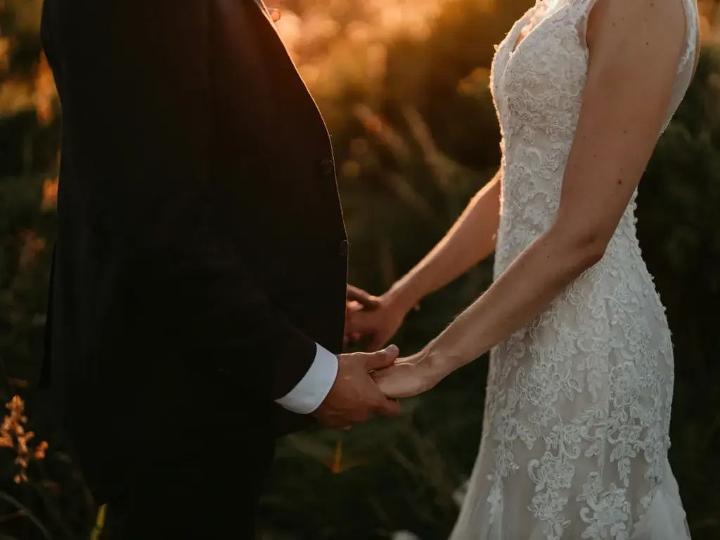 Los novios de la mano al atardecer