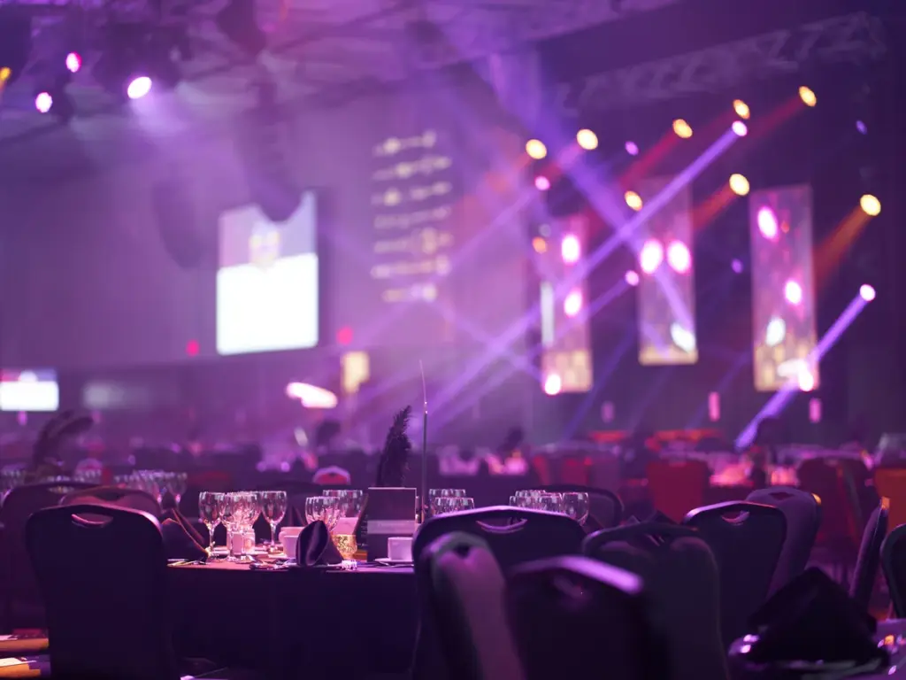 Sala de gala montada con mesas e iluminación de escenario