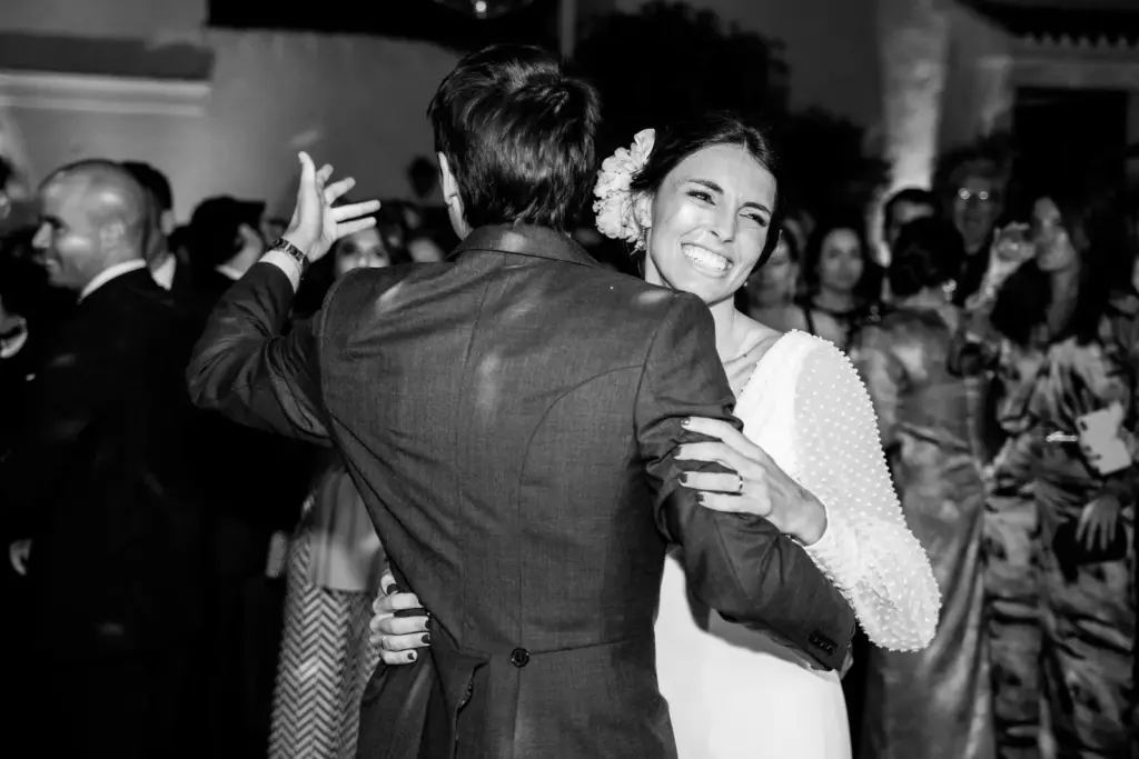 Los novios bailando abrazados mientras los invitados los rodean