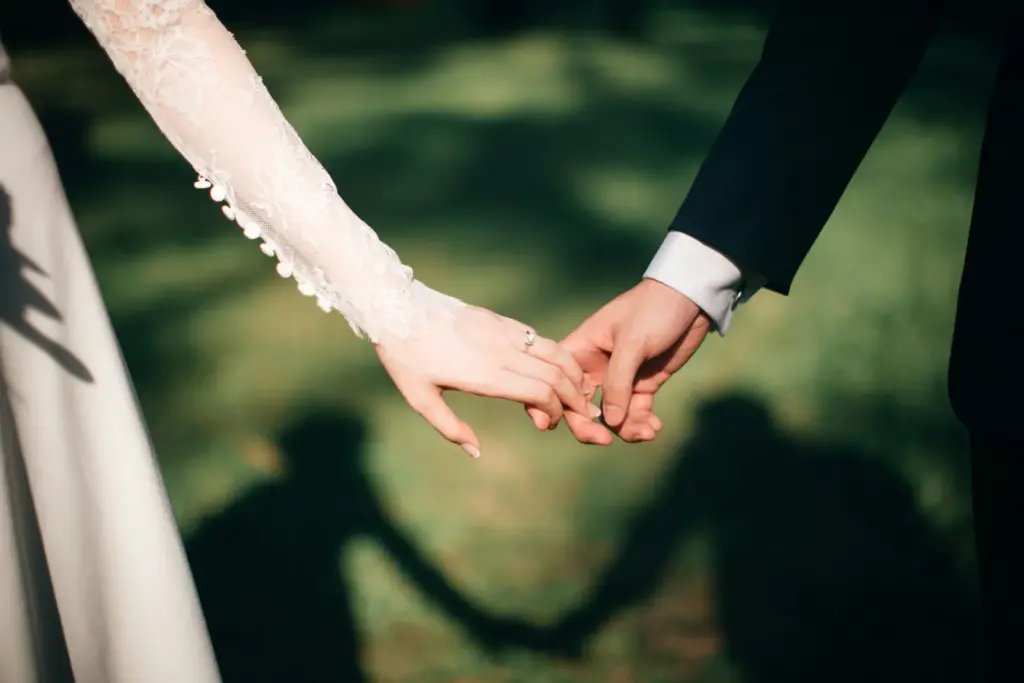 Manos de los novios entrelazadas durante la celebración de una boda