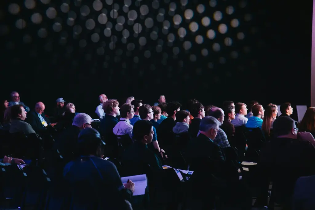 Público sentado siguiendo una ponencia en un evento corporativo